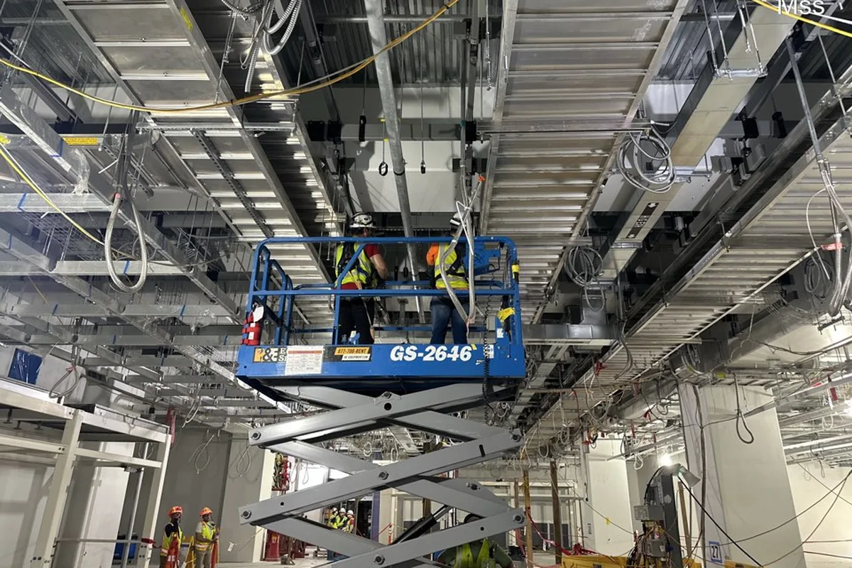 Two-person crew on a scissor lift under the deck